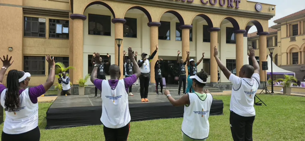 Judicial officers following a guided warm-up outside the Supreme Court of Uganda